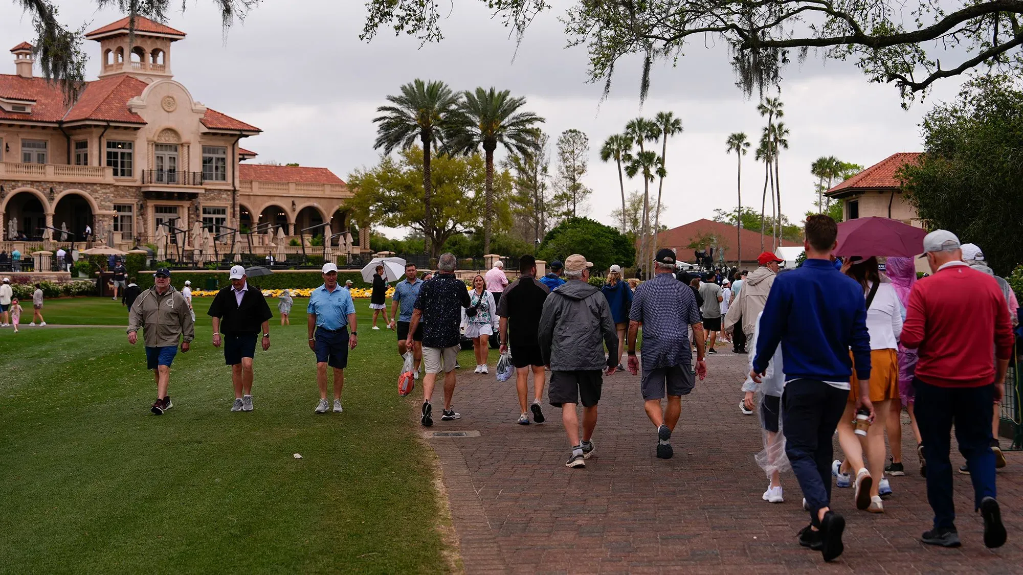 مشجعون يتوجهون نحو ملعب TPC Sawgrass في بونتي فيدرا بيتش، مع أجواء غائمة وتهديد بالعواصف، خلال جولة رابطة لاعبي الجولف المحترفين.
