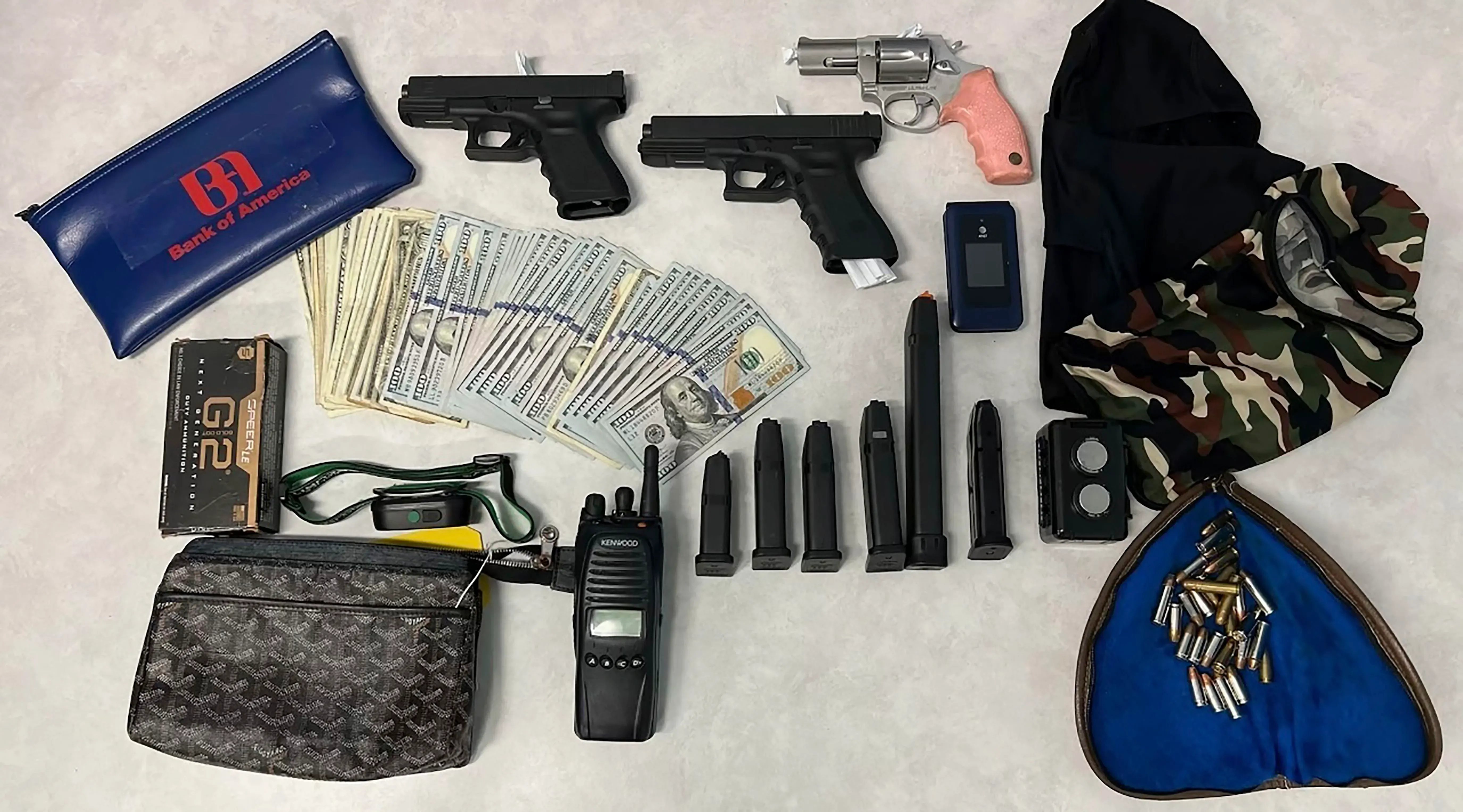 عناصر مسروقة تشمل أسلحة نارية، نقود، وأدوات سطو، تم استردادها خلال عملية للشرطة في لوس أنجلوس ضد عصابة سطو.