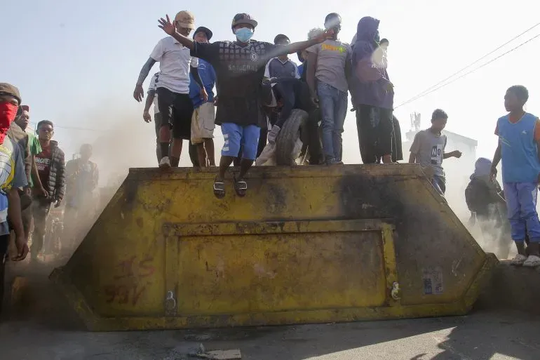 محتجون يقفون فوق حاوية نفايات خلال مظاهرة مناهضة للحكومة في مدغشقر، حيث تصاعدت التوترات بسبب الفساد وانقطاع الكهرباء.