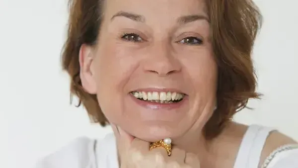 ابتسامة ألكسندرا فروليتش، الروائية الألمانية الشهيرة، التي عُثر عليها ميتة في قاربها المنزلي في هامبورغ، مما أثار تحقيقاً في جريمة قتل.