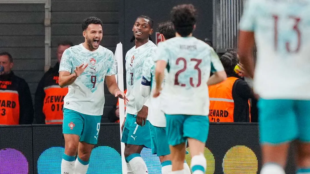 لاعبو منتخب البرتغال يحتفلون بهدف خلال مباراة حماسية ضد الدنمارك في دوري الأمم الأوروبية، مع تفاعل الجماهير في الخلفية.
