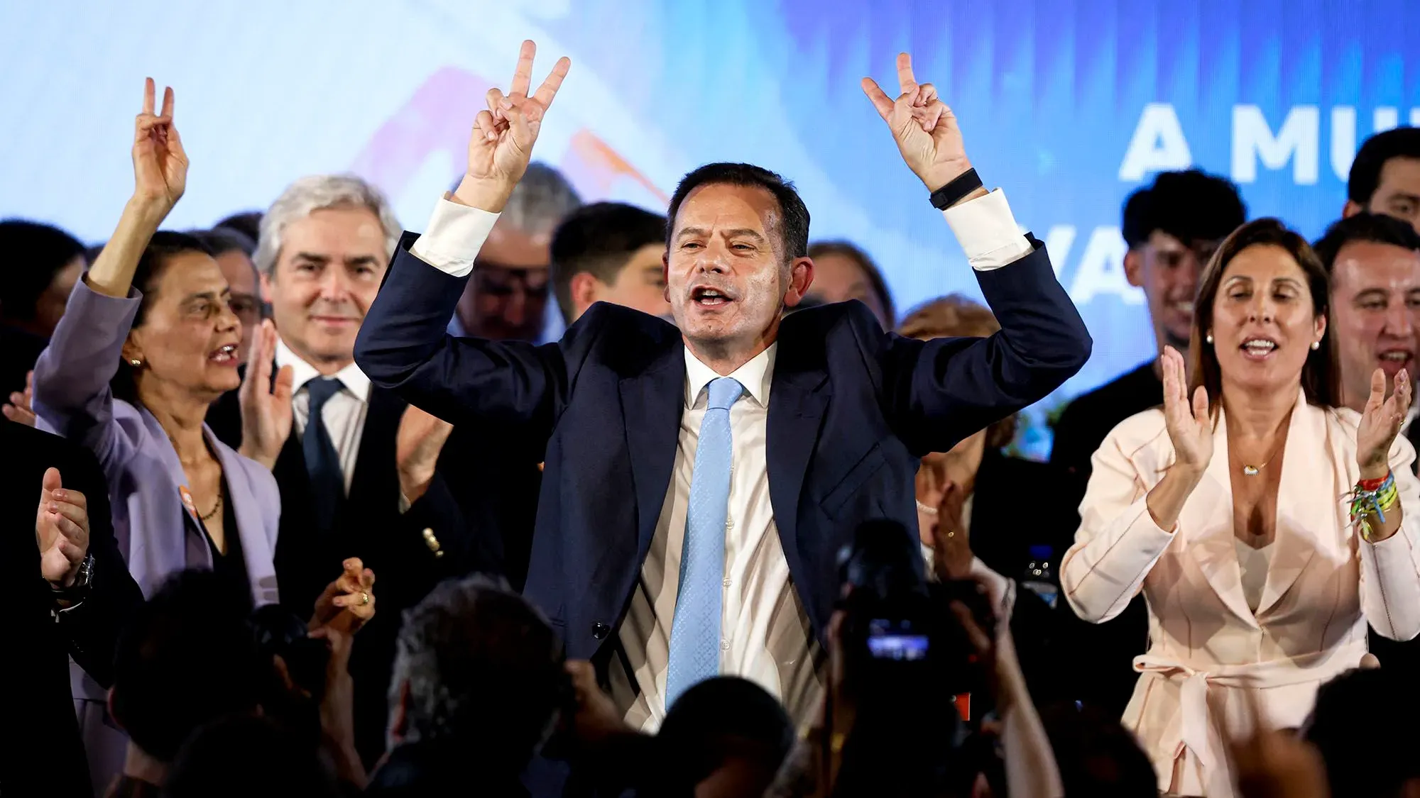 رئيس الوزراء لويس مونتينيغرو يحتفل بفوز حزبه في الانتخابات البرلمانية، محاطًا بأنصاره الذين يهتفون، مما يعكس حالة من التفاؤل السياسي.