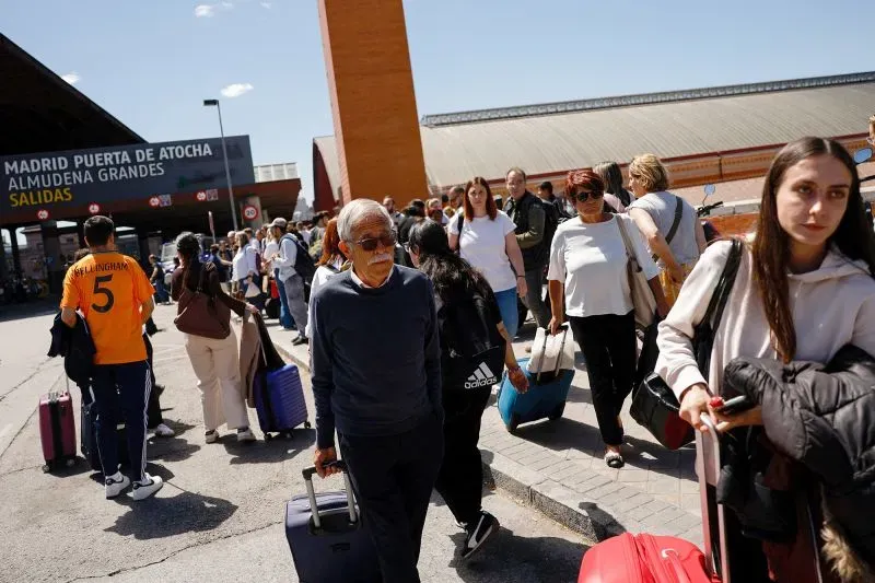 ازدحام كبير أمام محطة قطارات "مدريد بويرتا دي أتوتشا"، حيث ينتظر المسافرون مع حقائبهم بعد انقطاع التيار الكهربائي.