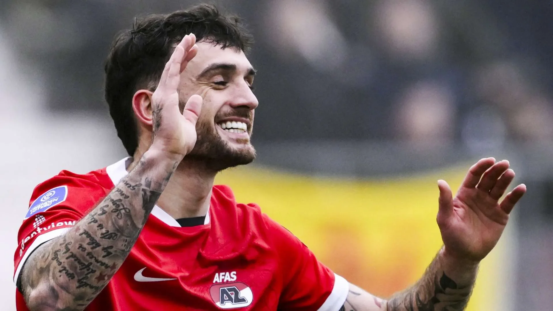 لاعب كرة القدم تراي باروت يرتدي قميص AZ Alkmaar الهولندي يرفع يديه ويبتسم بعد تسجيل هدف حاسم في الدوري الأوروبي.