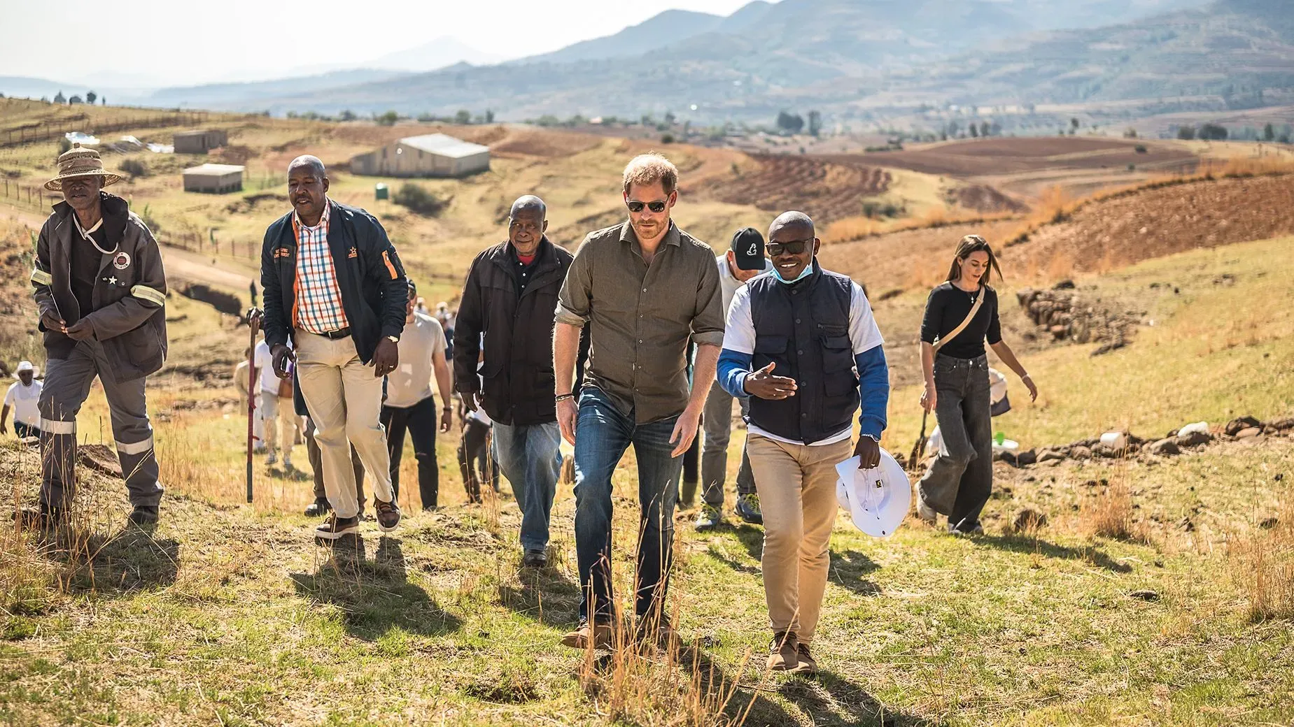 الأمير هاري مع مجموعة من الأشخاص في منطقة ريفية في ليسوتو، حيث يساهم في دعم مؤسسة سنتيبال لمساعدة الشباب المصابين بفيروس الإيدز.