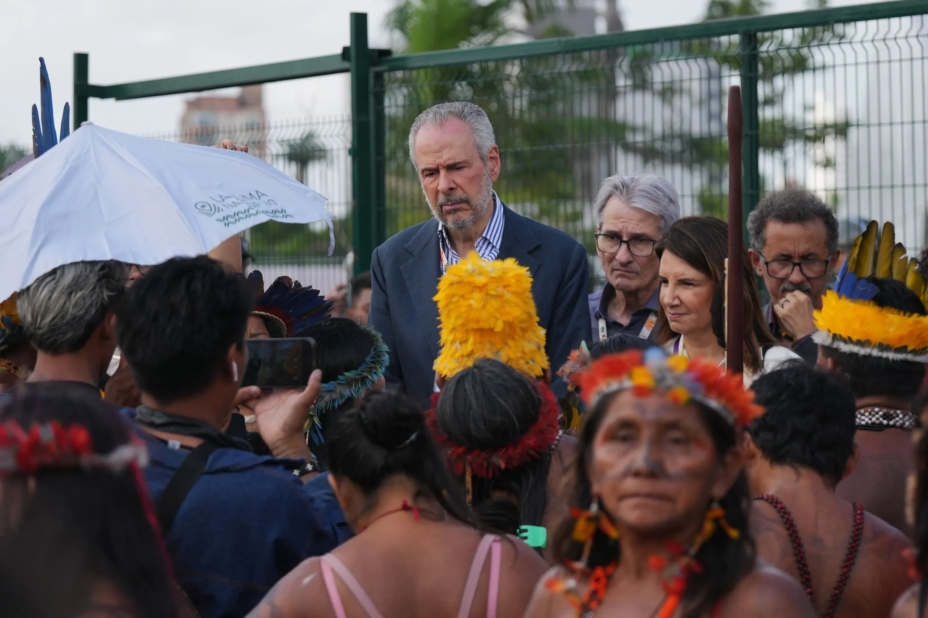 محتجون من السكان الأصليين يحيطون برئيس مؤتمر المناخ، مع مظاهر تقليدية، خلال احتجاج سلمي أمام مؤتمر الأمم المتحدة للمناخ في البرازيل.