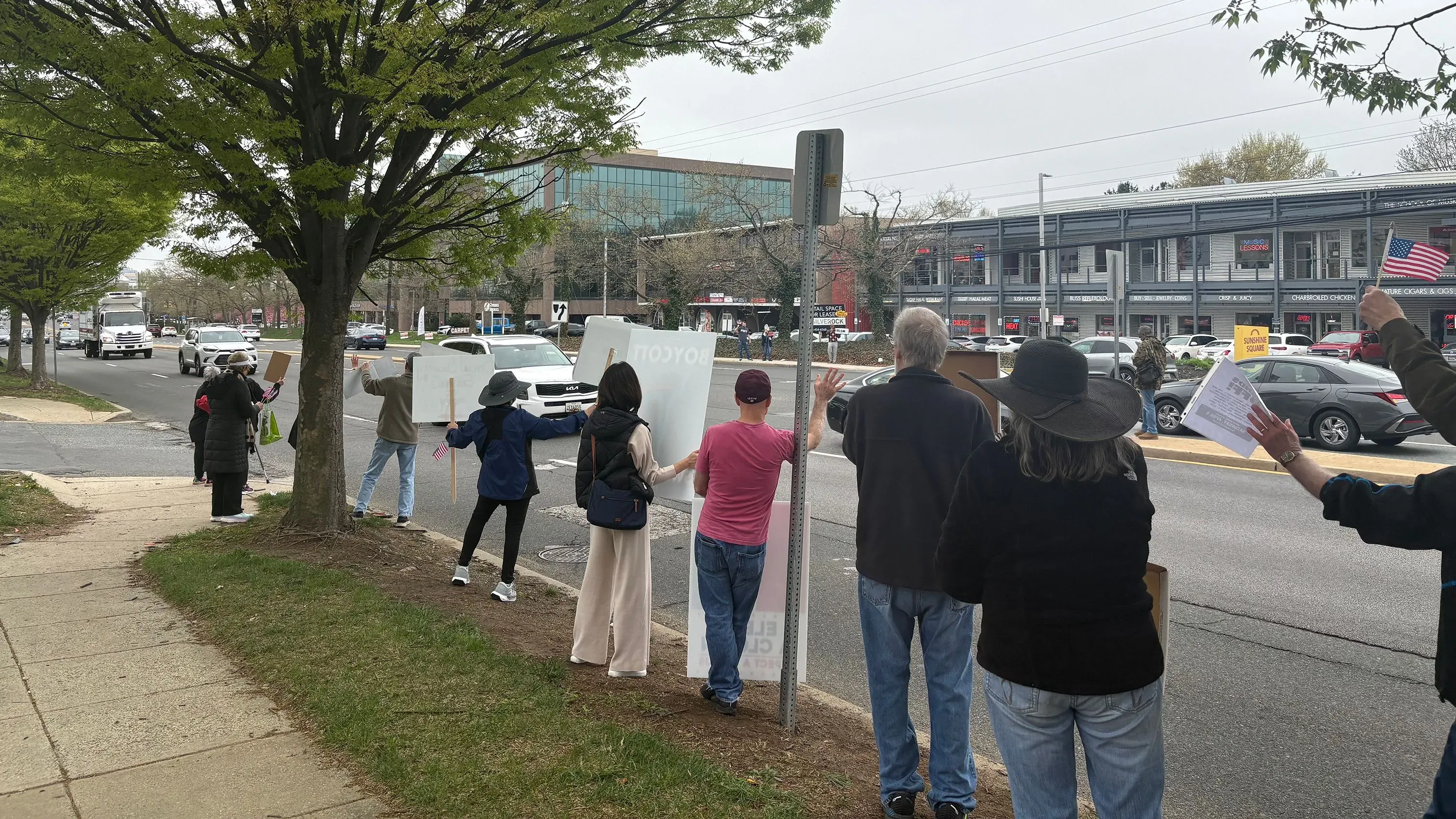 محتجون يحملون لافتات خارج صالة عرض تسلا في روكفيل بولاية ماريلاند، تعبيرًا عن معارضتهم لإدارة إيلون ماسك.