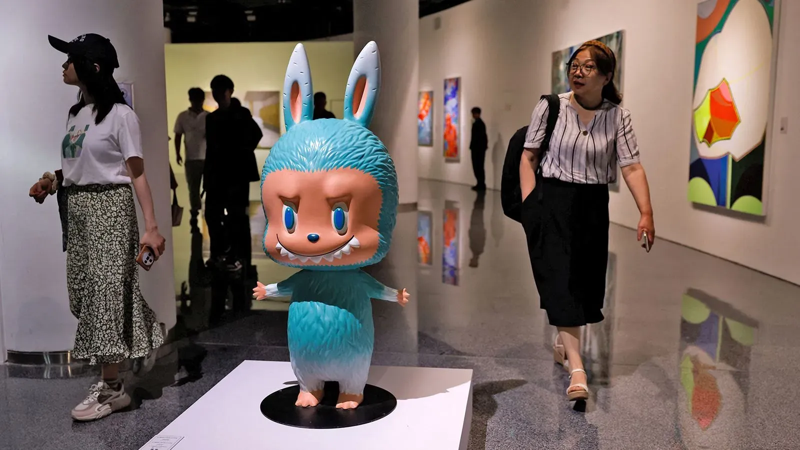 تمثال لابوبو النادر باللون الأخضر النعناعي، بطول 131 سم، مع تفاصيل وجه عفريت مبتسم، في معرض فني في بكين.