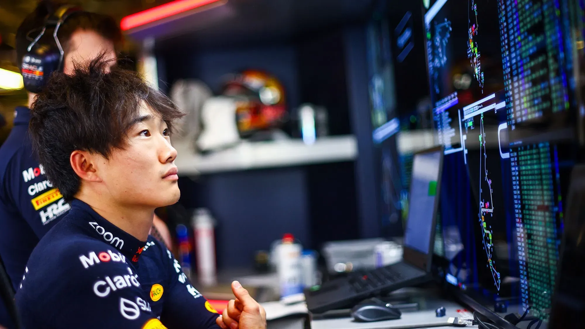 يوكي تسونودا يجلس أمام شاشة عرض بيانات سباقات، مع التركيز على التحليل الفني، في سياق تغييرات فريق ريد بُل.