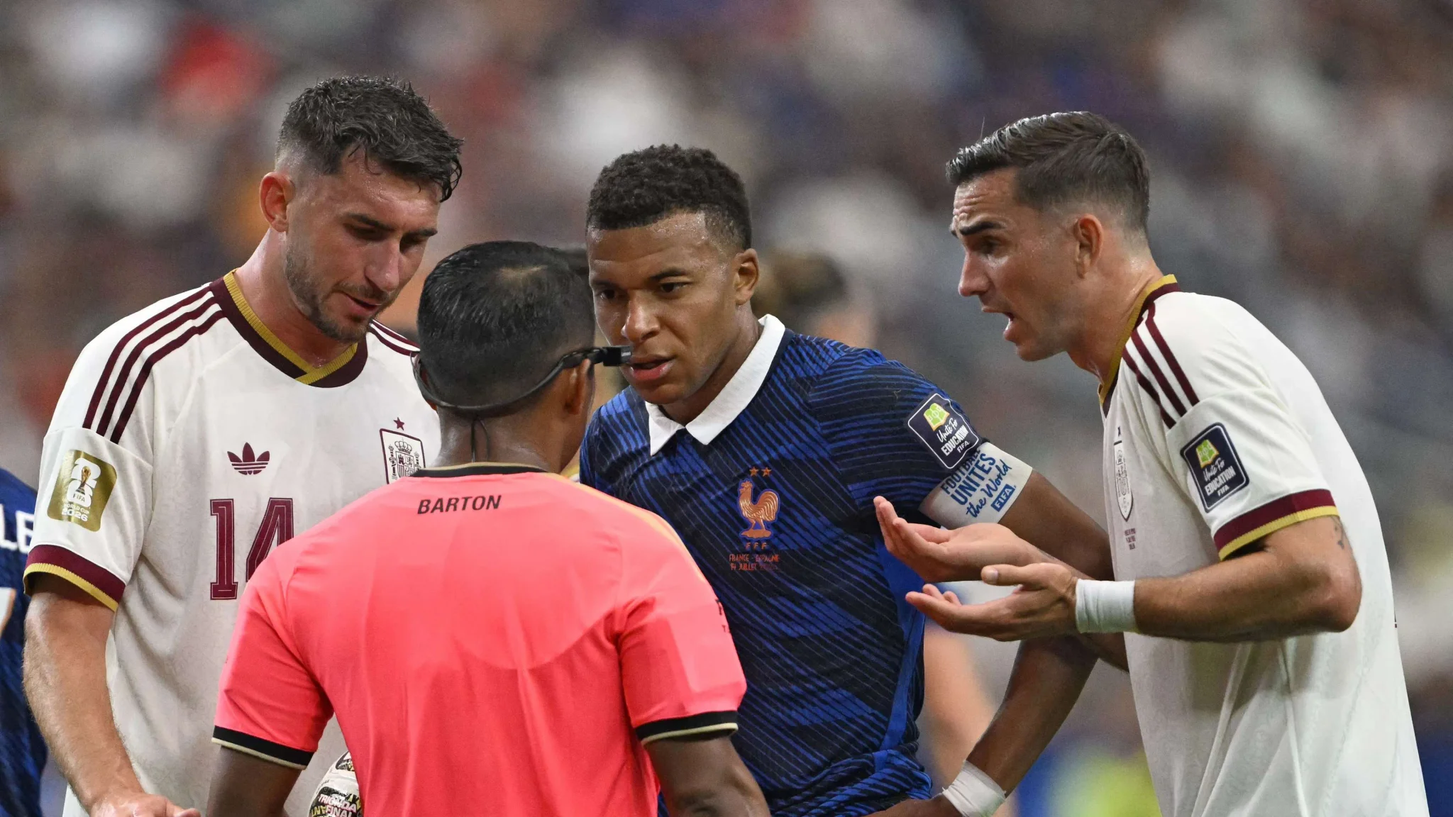 حكم المباراة إيفان بارتون يتلقى احتجاجات من لاعبي فرنسا وإسبانيا خلال نصف نهائي كأس العالم 2022.