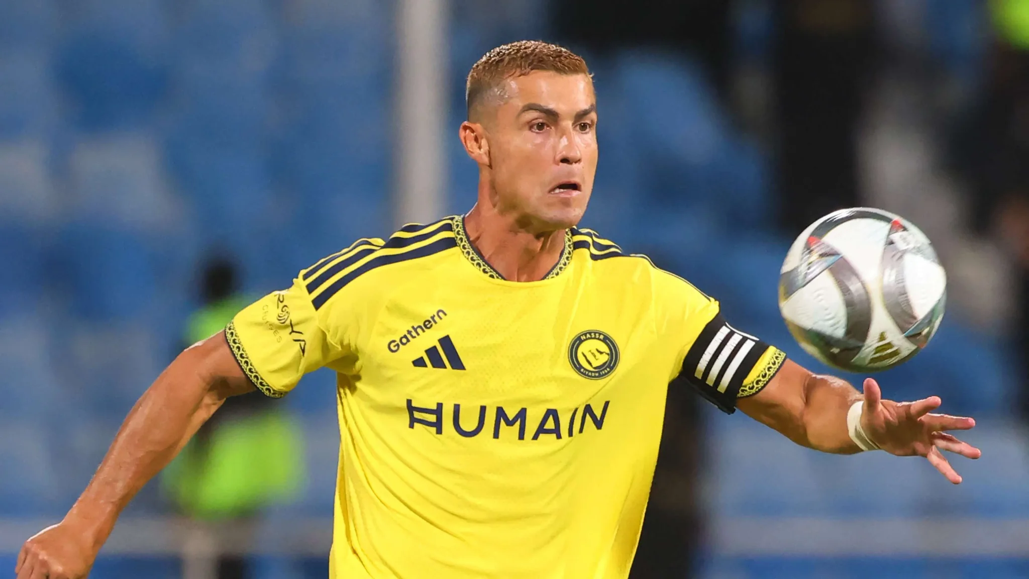 لاعب كرة قدم يرتدي قميص النصر الأصفر يركض نحو الكرة خلال مباراة دوري روشن للمحترفين.