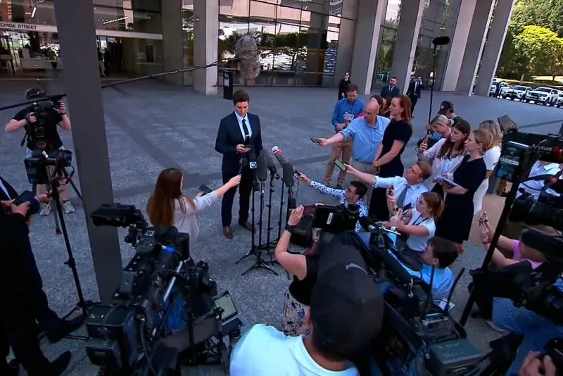 مؤتمر صحفي أمام المحكمة حول قضية قتل غير عمد لطفلة بسبب رفض علاجها الطبي، مع وجود العديد من الصحفيين والكاميرات.