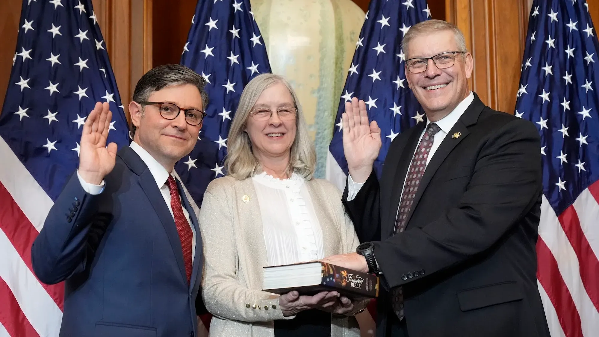 النائب الجمهوري باري لودرملك ورئيس مجلس النواب مايك جونسون أثناء مراسم بدء الكونغرس الجديد، مع العلم الأمريكي خلفهم.