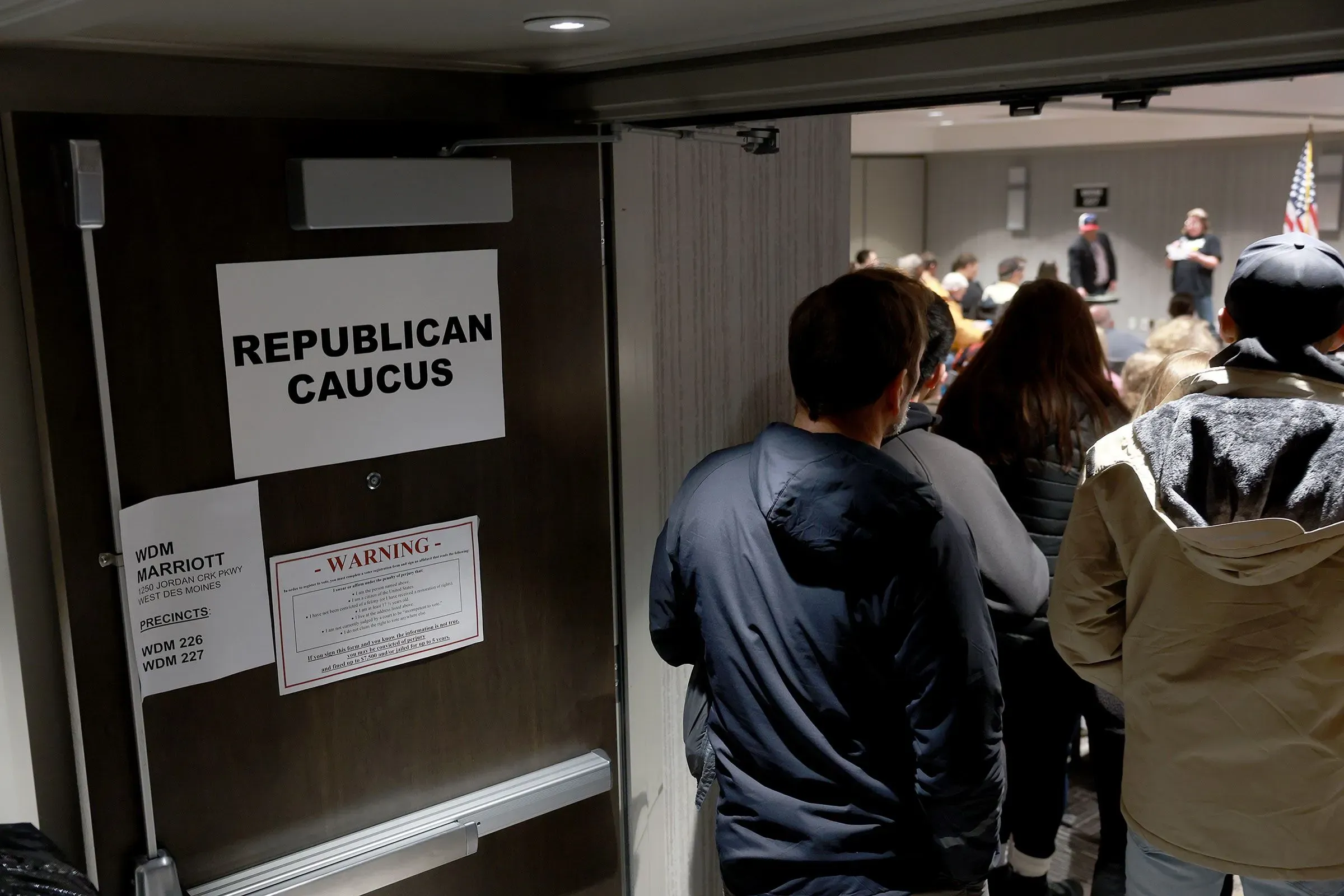 مدخل قاعة اجتماع الجمهوريين مع لافتة "اجتماع الجمهوريين" في الخلفية، حيث يتجمع الحضور استعدادًا للنقاشات السياسية.