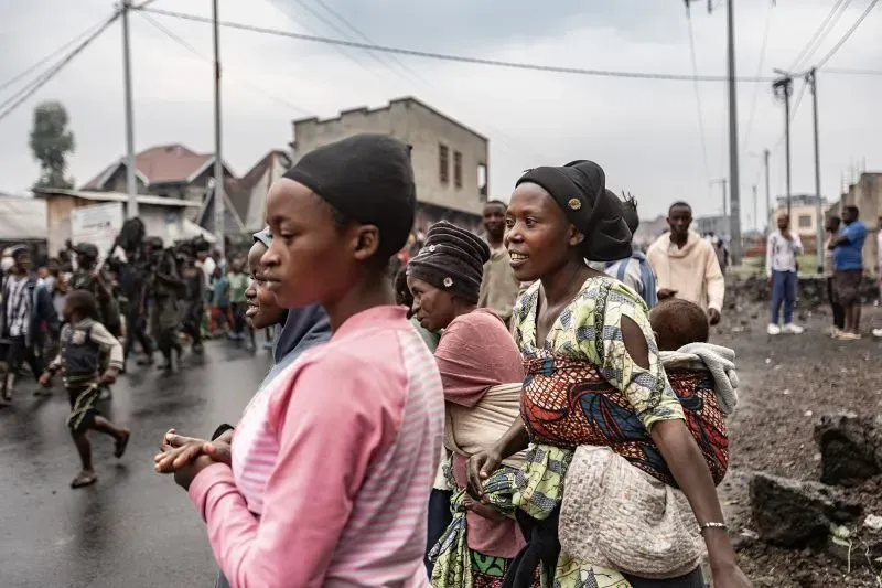 نساء وأطفال في شوارع غوما، مع مظاهر القلق والخوف بسبب القتال المستمر والمواجهات المسلحة في المدينة.