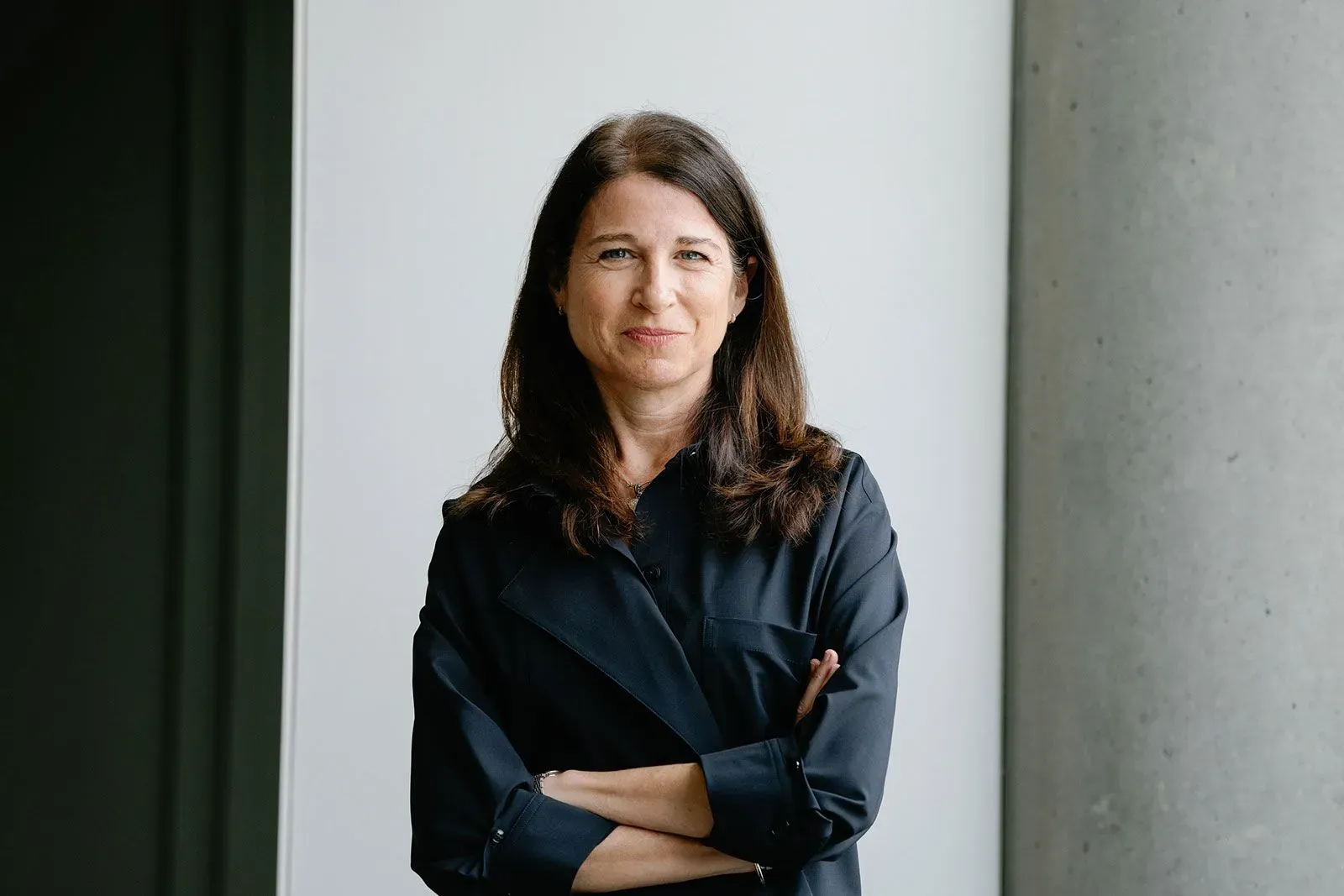 صورة لجولي بورنشتاين، الرئيسة التنفيذية لشركة Daydream، مبتسمة ومرتدية قميصاً أسود، تقف أمام جدار أبيض، تعكس شغفها بصناعة الأزياء والتكنولوجيا.