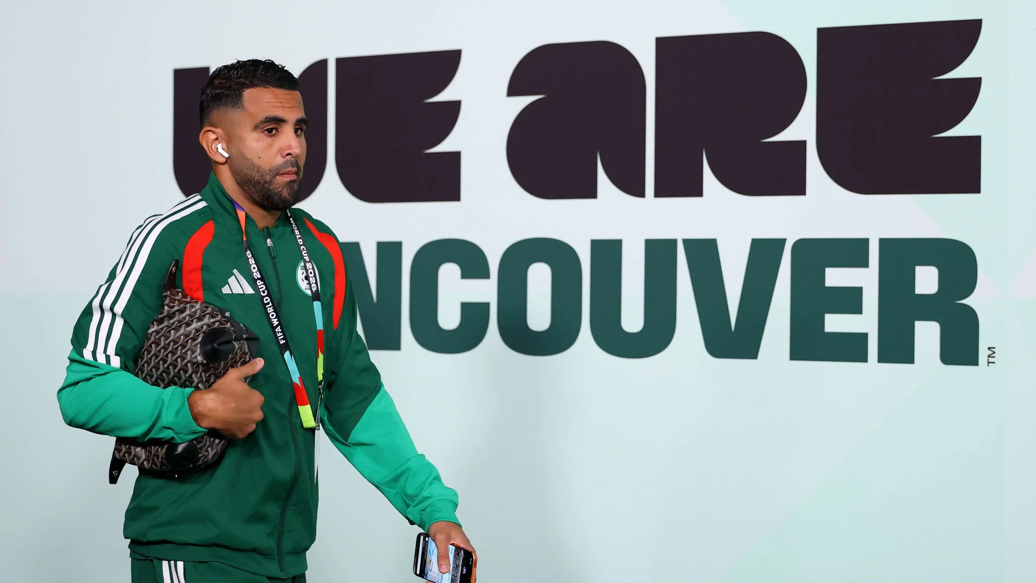 رياض محرز يرتدي زي المنتخب الجزائري أثناء وصوله لمكان بطولة كأس العالم 2026 استعداداً لانتقاله إلى نادي الشمال القطري.