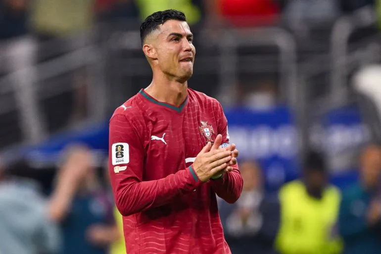 كريستيانو رونالدو يرتدي زي المنتخب البرتغالي لكرة القدم ويصفق في ملعب خلال مباراة دولية.