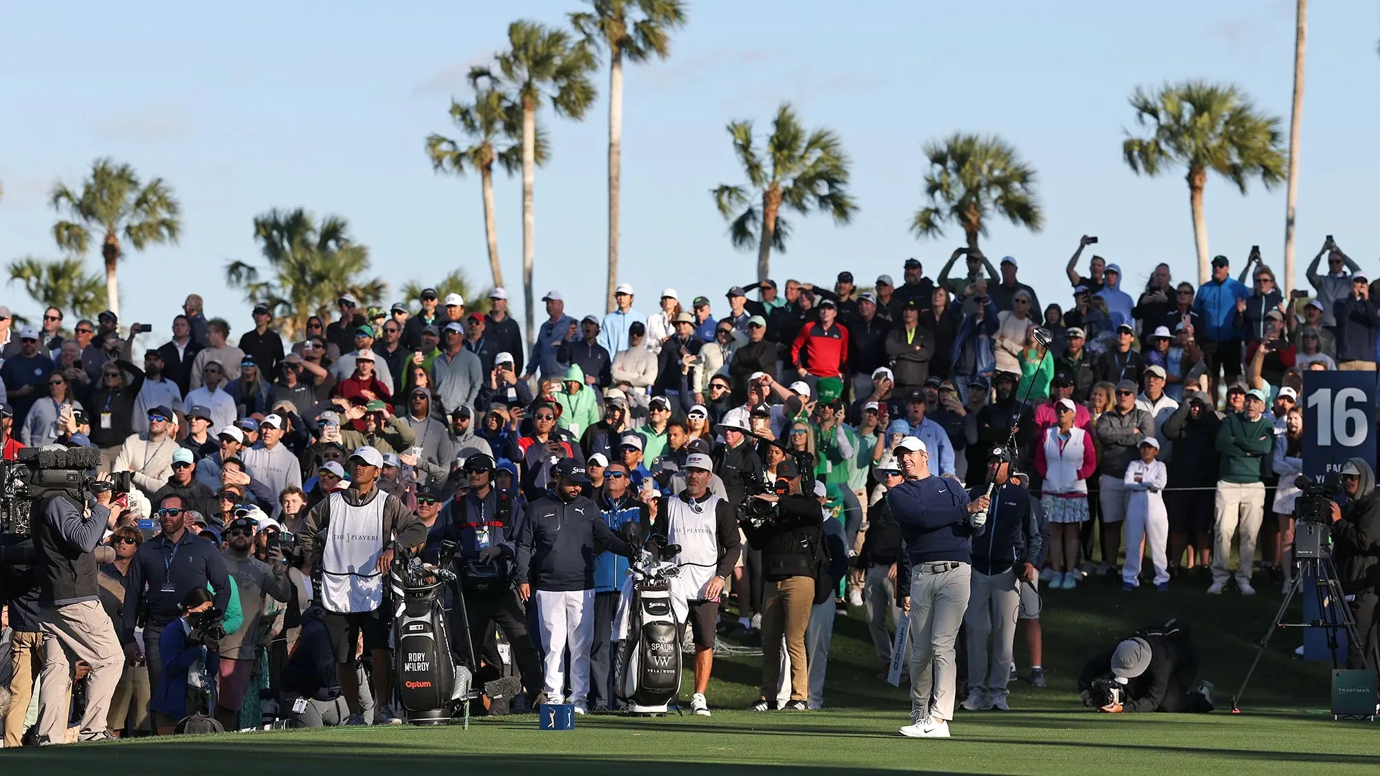 روري ماكلروي يتأهب لضرب الكرة أمام حشد كبير من المشجعين خلال بطولة بلايرز، مع وجود لاعبين آخرين في الخلفية.