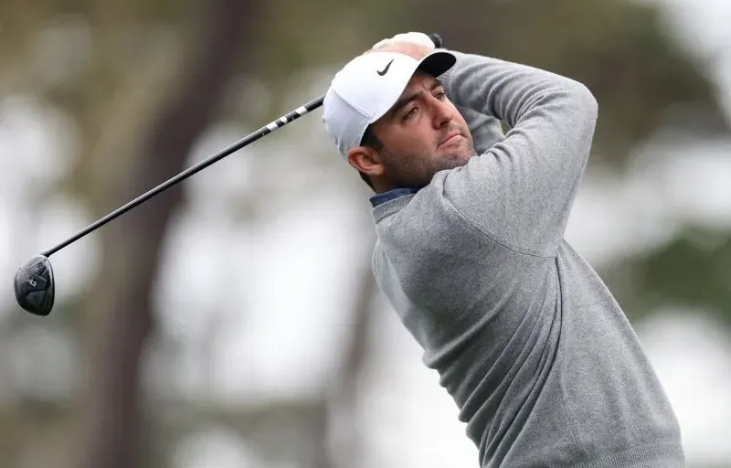 لاعب جولف يضرب الكرة أثناء المنافسة في بطولة بيبل بيتش للمحترفين، مع التركيز على التركيز الجاد في تحركاته.