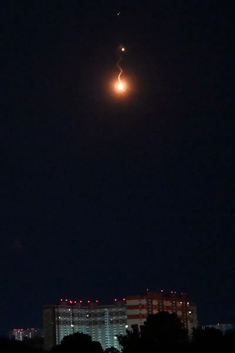 صورة تظهر سماء كييف ليلاً مع توهج ناري، يُحتمل أنه نتيجة هجوم بطائرات مسيرة، بينما تُرى مباني سكنية في الأسفل.