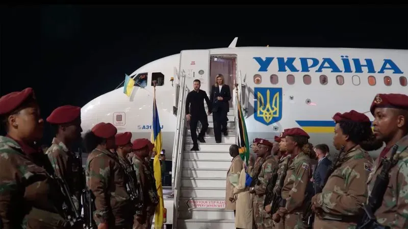 رئيس أوكرانيا فولوديمير زيلينسكي يصل إلى مطار محاط بجنود مسلحين، في سياق تصاعد التوترات مع روسيا.