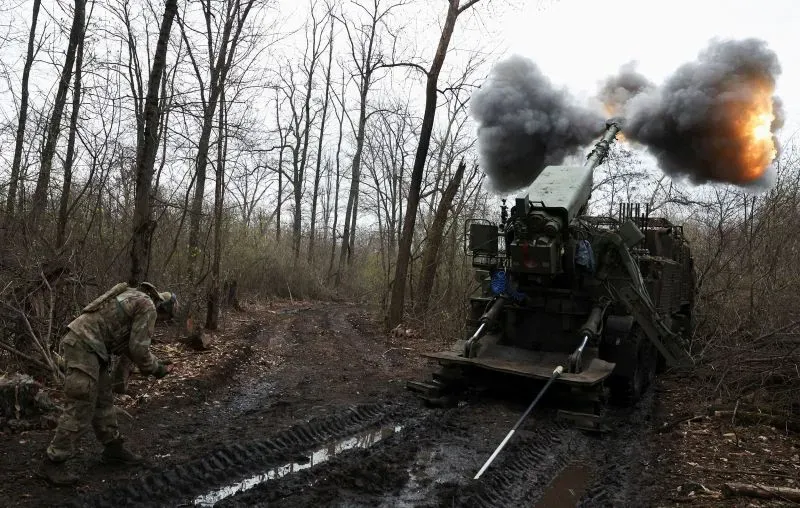 مدفعية روسية تطلق النار في غابة، مع تصاعد الدخان والنيران، في إطار التصعيد العسكري على خط الجبهة في أوكرانيا.