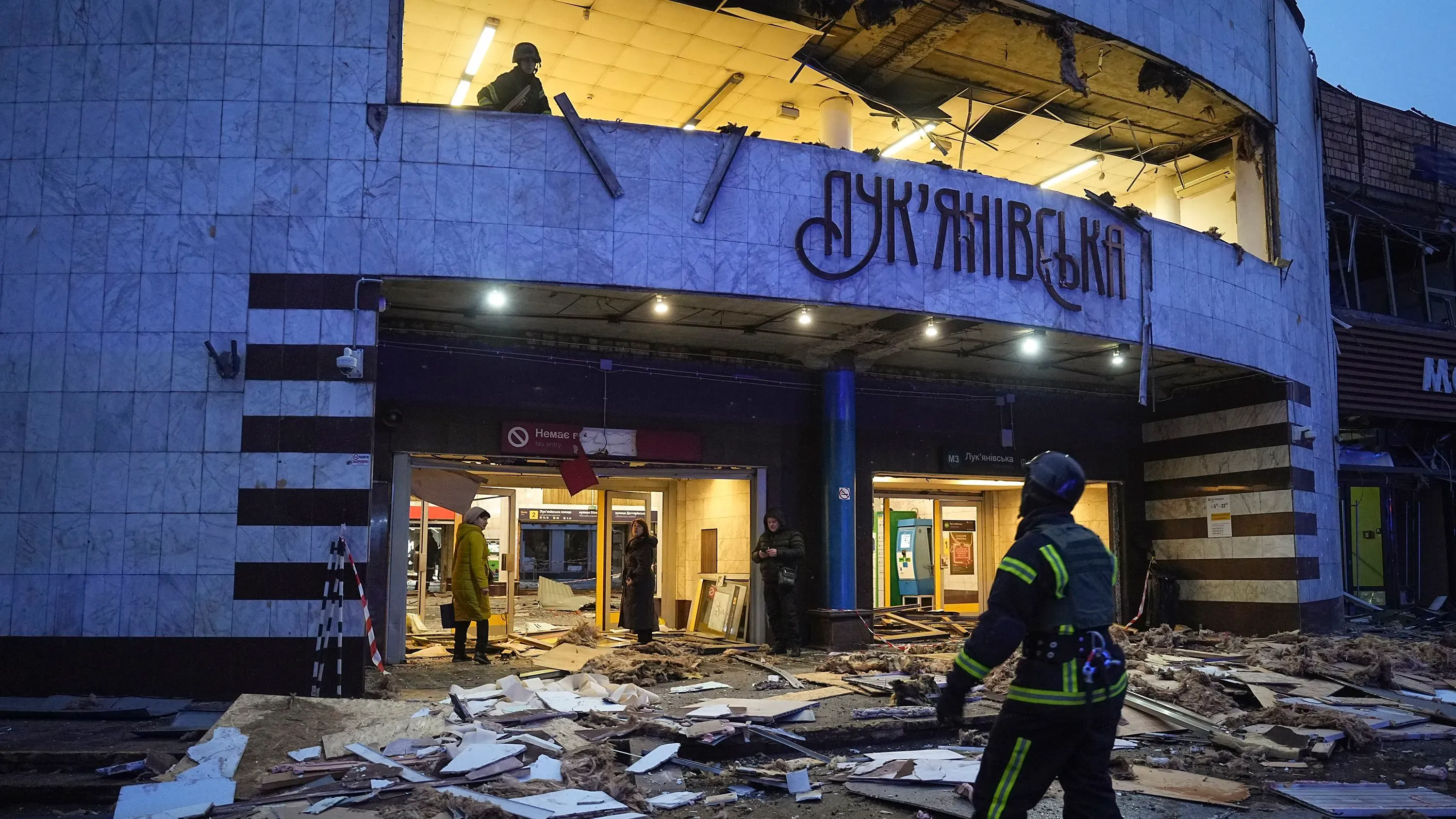 تظهر الصورة محطة مترو في كييف متضررة جراء الهجوم، مع وجود debris وأفراد من الإنقاذ أثناء البحث عن ضحايا.