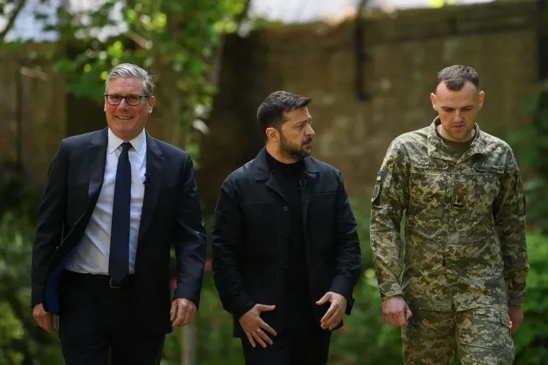 اجتماع بين الرئيس الأوكراني فولوديمير زيلينسكي ورئيس الوزراء البريطاني كير ستارمر، مع وجود ضابط عسكري، في بيئة خارجية.