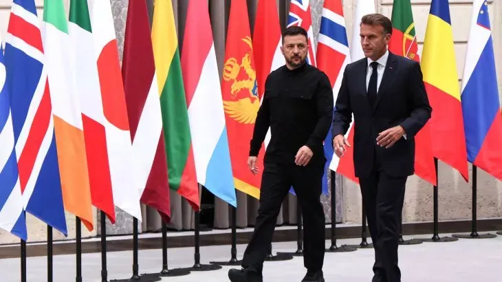 اجتماع بين الرئيس الأوكراني فولوديمير زيلينسكي والرئيس الفرنسي إيمانويل ماكرون، مع أعلام الدول المشاركة في الخلفية، خلال قمة لمناقشة الضمانات الأمنية لأوكرانيا.