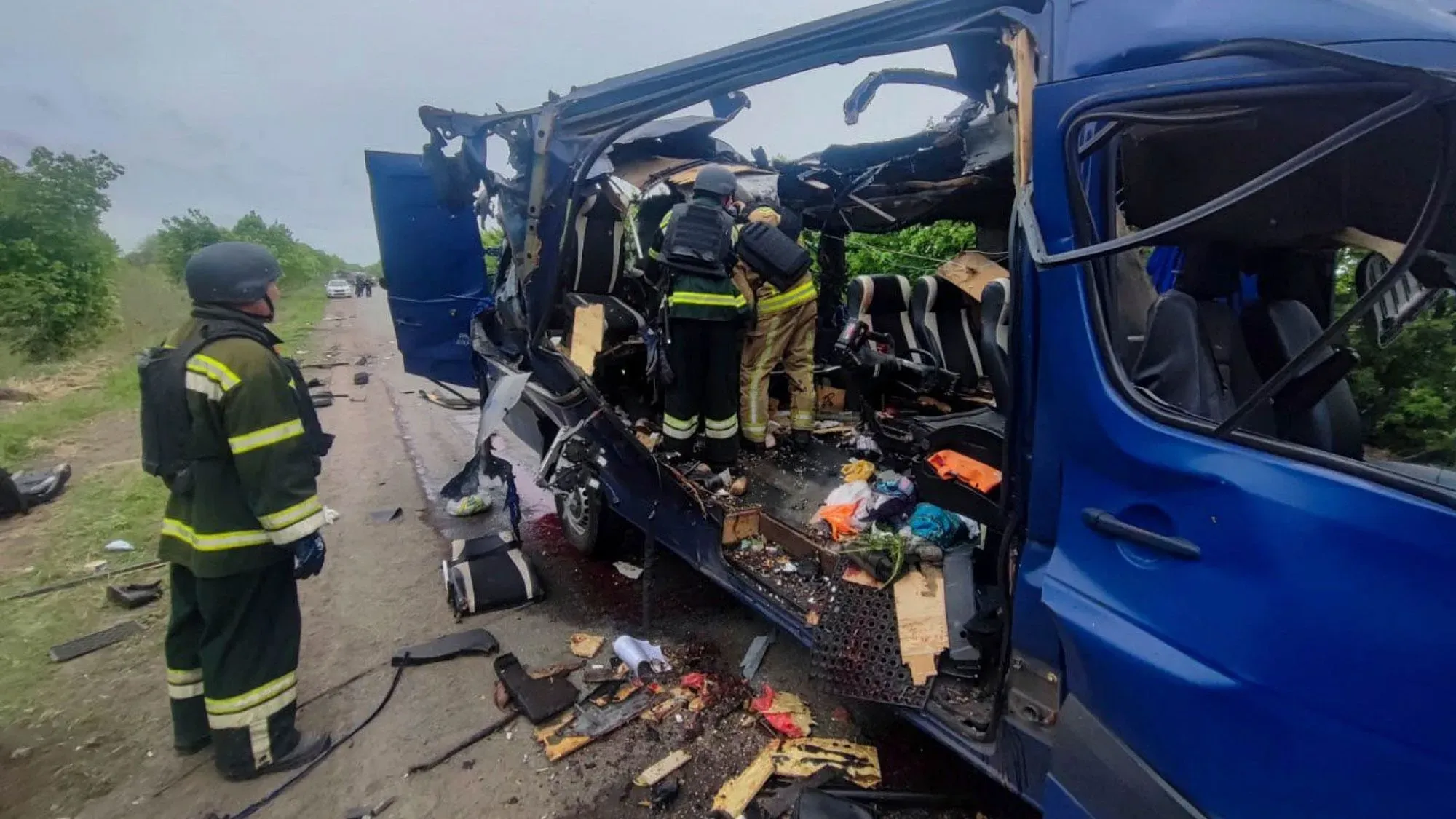 حافلة مدنية مدمرة في أوكرانيا بعد هجوم بطائرة مسيرة، حيث يظهر رجال الإطفاء وهم يعملون في موقع الحادث.