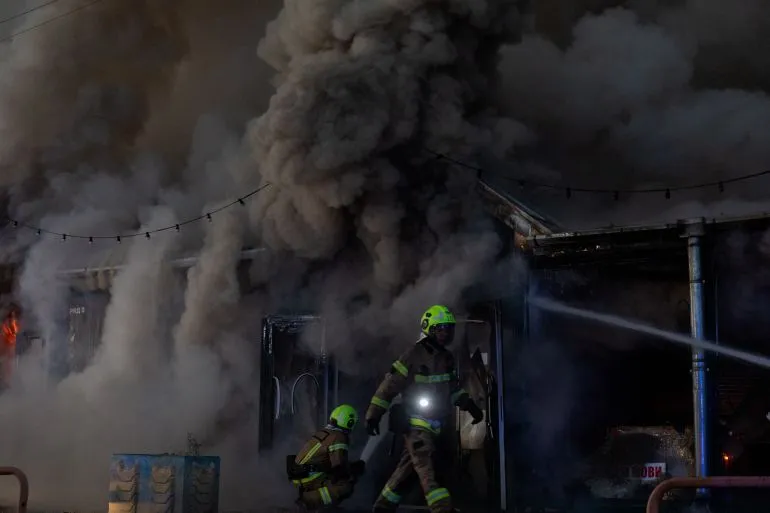 رجال إطفاء يواجهون دخاناً كثيفاً من حريق ناجم عن هجوم صاروخي في مدينة كريفي ريه الأوكرانية.
