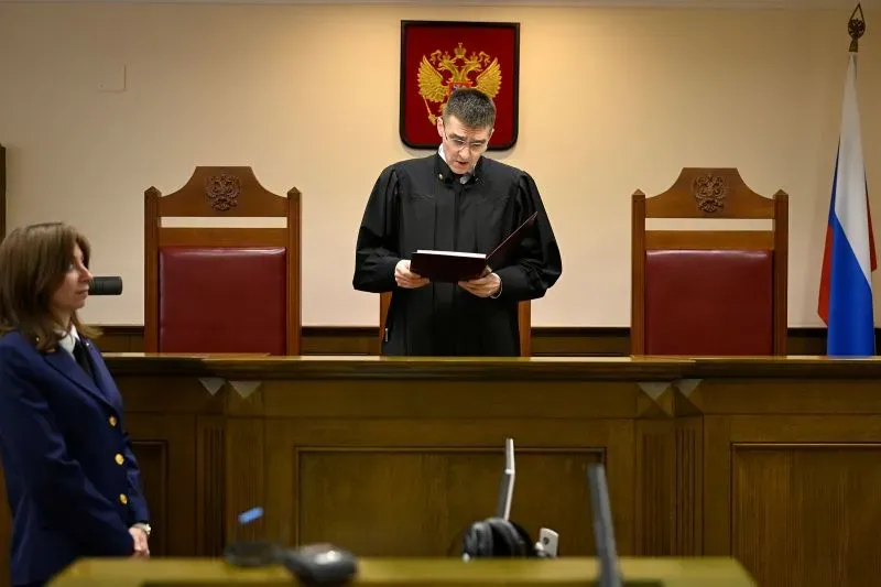 قرار المحكمة العليا في روسيا برفع الحظر عن حركة طالبان، مع القاضي يقرأ الحكم في قاعة المحكمة، بينما تظهر رموز الدولة الروسية.