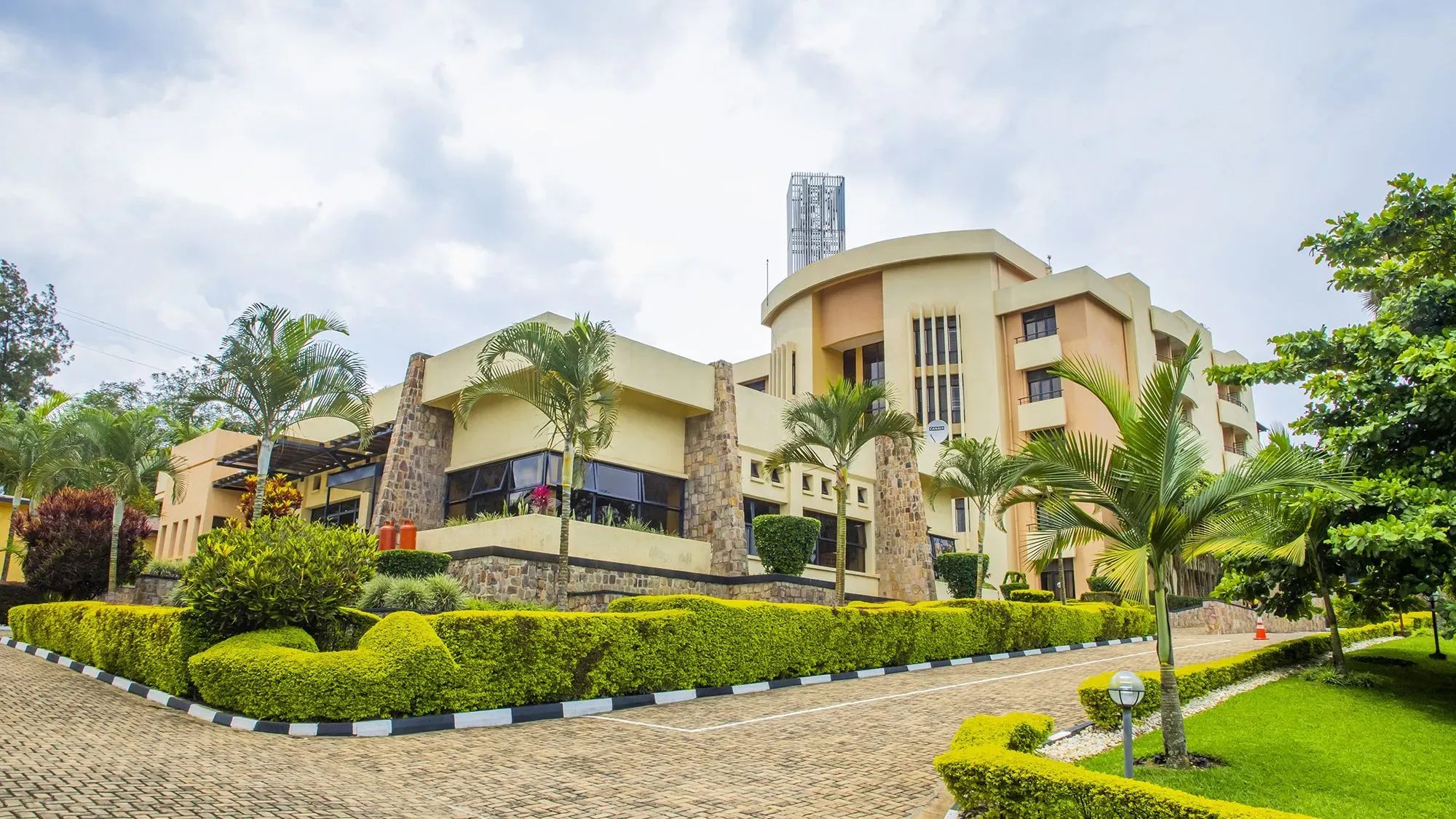 مبنى حكومي في رواندا محاط بأشجار ونباتات، يعكس الجهود المبذولة لاستقبال المهاجرين في إطار المحادثات مع الولايات المتحدة.