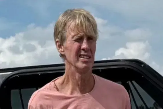 رجل يبدو مضطربًا يقف بجوار سيارة، مع تعبير وجه يعكس التوتر، في سياق محاولة اغتيال الرئيس السابق ترامب.