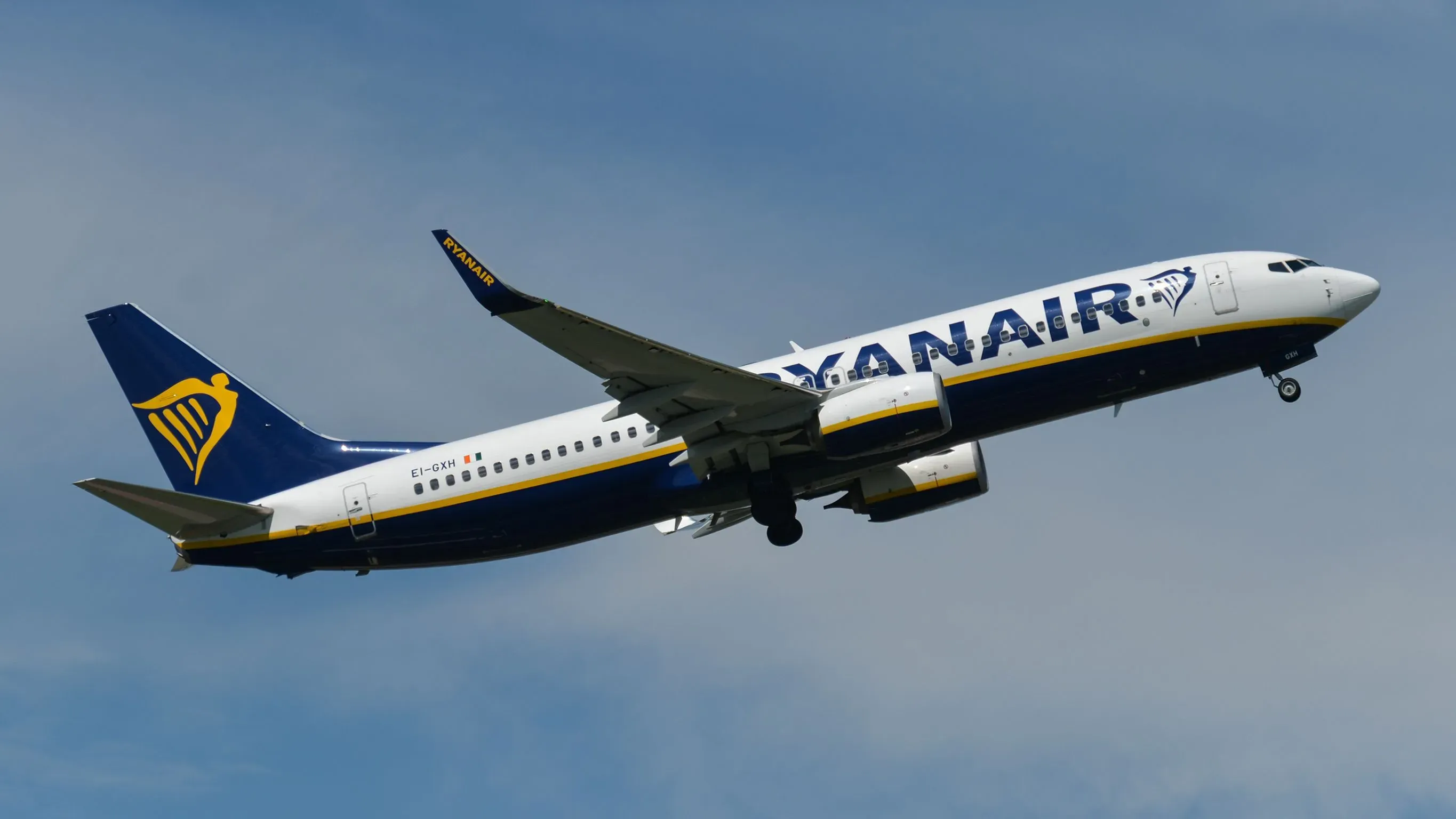 طائرة راين إير تحلق في السماء، تعكس سياسة الشركة الصارمة ضد السلوك المشاغب للركاب وتأثيره على الرحلات.