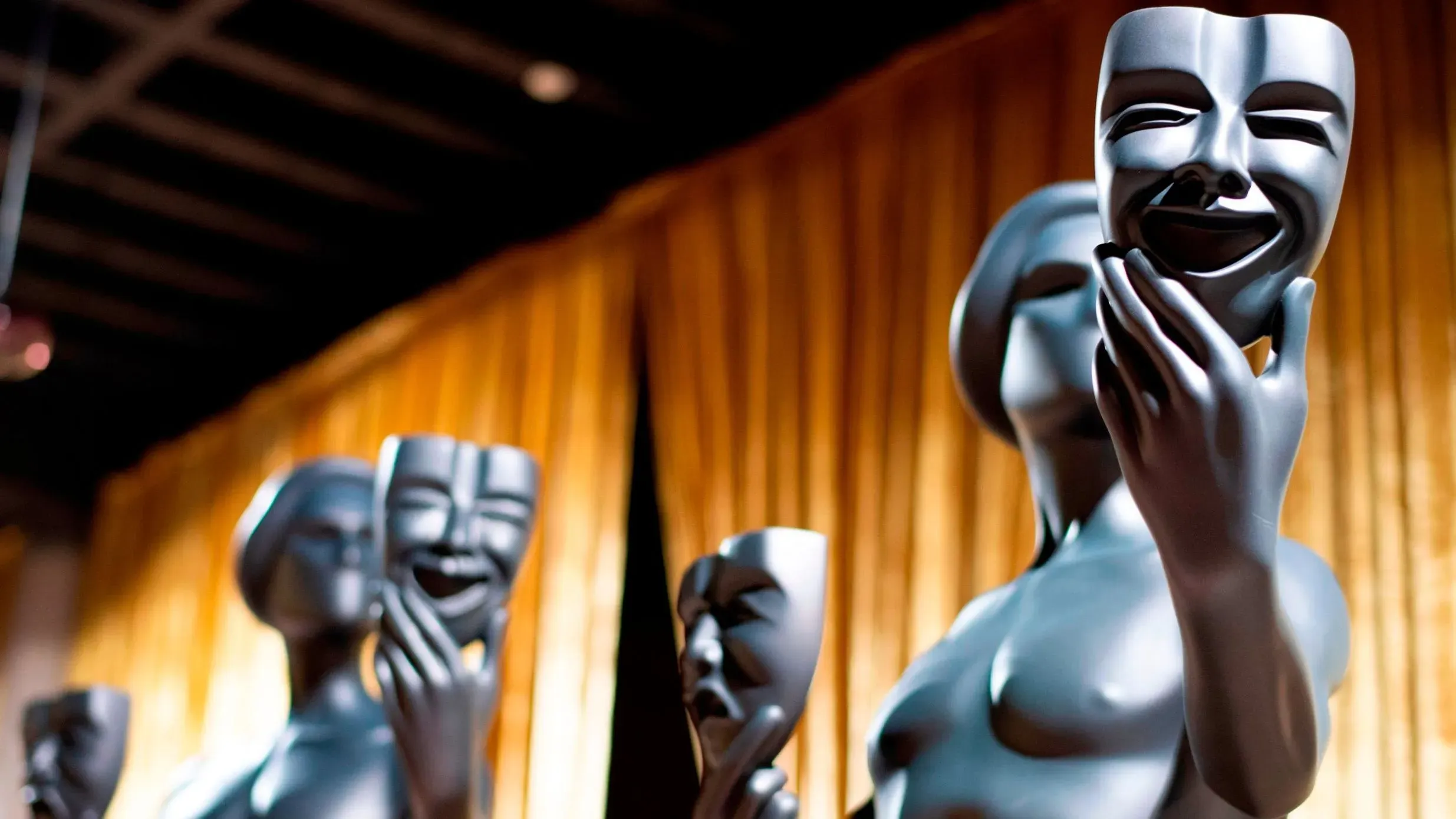 تمثال رمزي يعبر عن فن التمثيل، يظهر تفاصيل دقيقة لأقنعة تعبيرية، في خلفية دافئة، يرمز لجوائز نقابة ممثلي الشاشة.