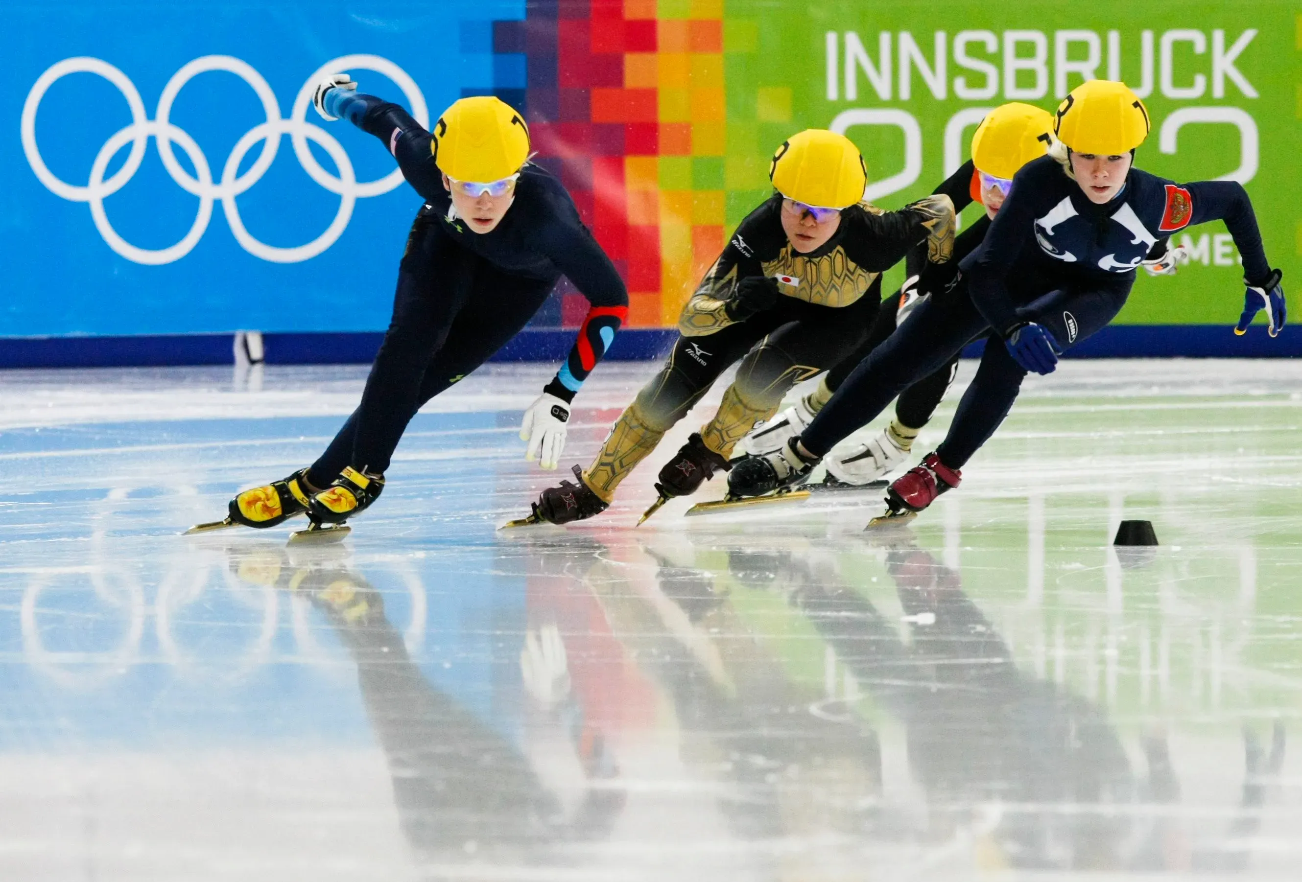 مجموعة من المتزلجين السريعين يتنافسون في دورة الألعاب الأولمبية، مع التركيز على الحركة الديناميكية والأداء العالي.