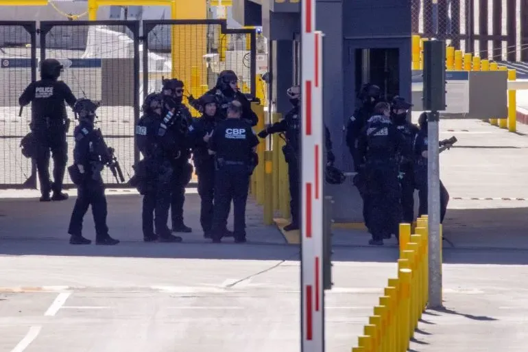 تجمع عناصر من إدارة الجمارك وحماية الحدود الأمريكية في نقطة تفتيش، مع تعزيزات أمنية واضحة، في سياق تراجع السفر الدولي.