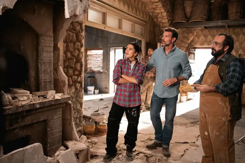 مجموعة من الأشخاص في موقع تجديد منزل إيطالي، حيث يتحدثون حول مشروع تجديد الفيلّا، مع تفاصيل من الديكور الداخلي.