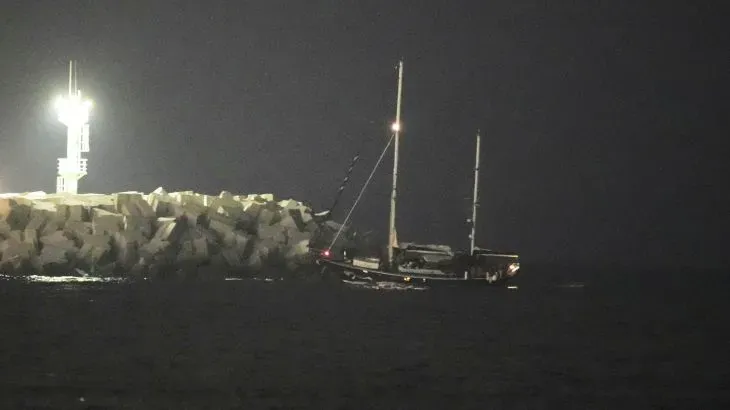 قارب إغاثة يقترب من ميناء أشدود ليلاً بعد استيلاء القوات الإسرائيلية عليه، مع تواجد أضواء الميناء في الخلفية.