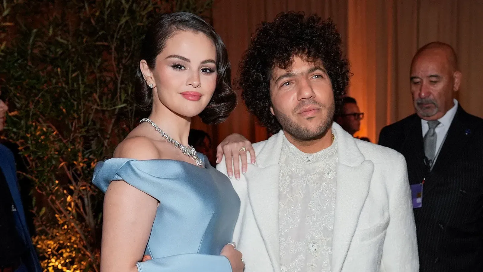 سيلينا غوميز وبيني بلانكو يتألقان معًا في مناسبة خاصة، حيث ترتدي غوميز فستان حفلة تخرج فوشيا، بينما يقف بلانكو بجانبها.