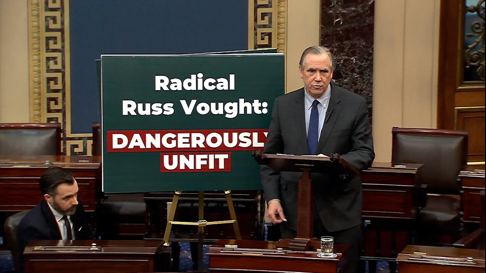 السيناتور جيف ميركلي يتحدث في مجلس الشيوخ ضد ترشيح راسل فوت، مع لافتة تشير إلى أنه "غير مؤهل بشكل خطير".