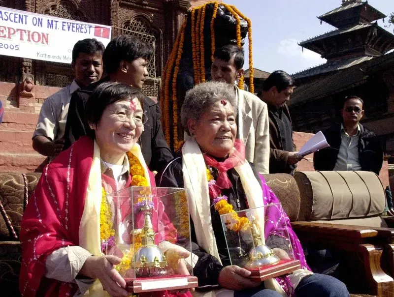 جونكو تاباي وبان دوو تتلقيان التكريم بعد تسلق إيفرست، محاطتين بالزهور والجوائز، في حفل في كاتماندو عام 2005.