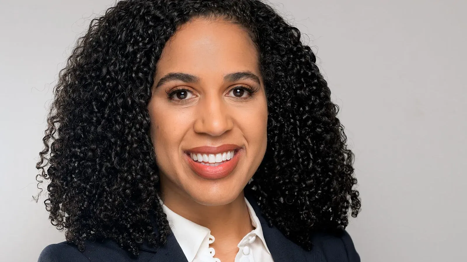 إريكا إيفانز، المدعية العامة السابقة، تبتسم في صورة احترافية، تعكس طموحها في الترشح لمنصب محامية المدينة في سياتل.