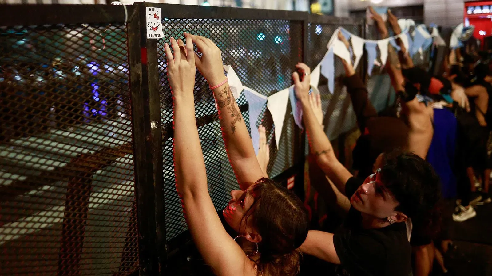 محتجون يضعون لافتات على سياج أمام الكونغرس في بوينس آيرس، تعبيراً عن استيائهم من سياسات الحكومة المتعلقة بالمعاشات.