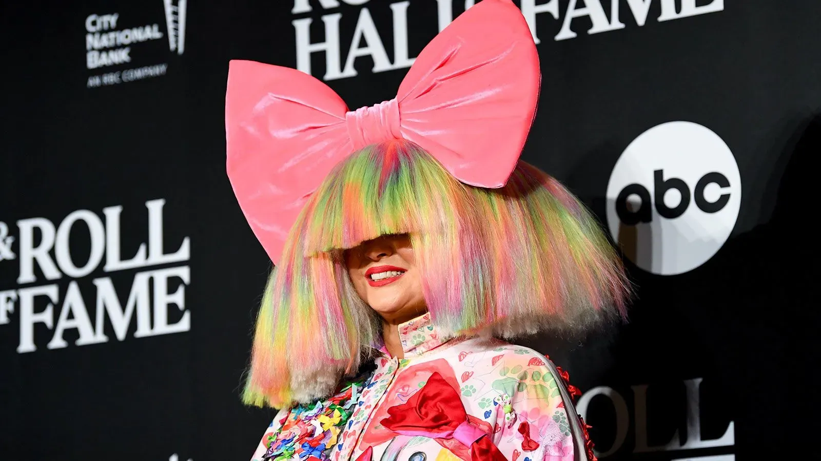 سيا، المغنية الأسترالية، تظهر بفستان ملون وقبعة كبيرة أثناء حدث موسيقي، في سياق إعلانها عن الطلاق من زوجها دانيال برنارد.