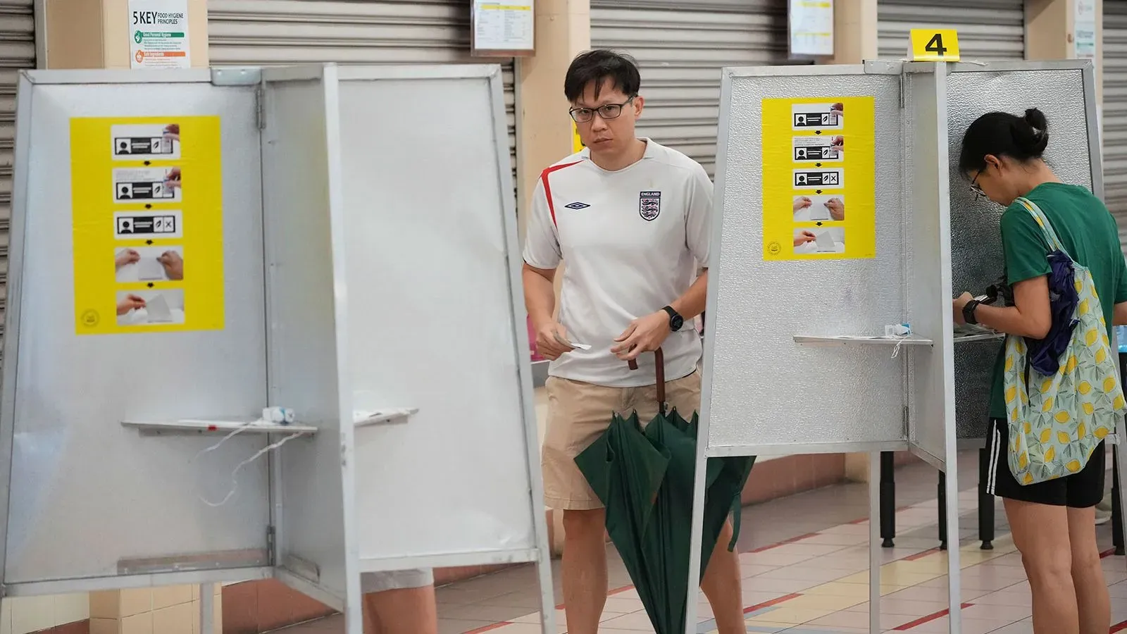 ناخبون في مركز اقتراع في سنغافورة، يظهرون أثناء التصويت في انتخابات مهمة لحزب العمل الشعبي وسط تحديات اقتصادية.