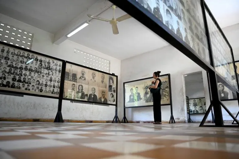 امرأة تتأمل صور ضحايا الخمير الحمر في متحف تول سلينغ للإبادة الجماعية، أحد المواقع المدرجة حديثاً في قائمة التراث العالمي لليونسكو.