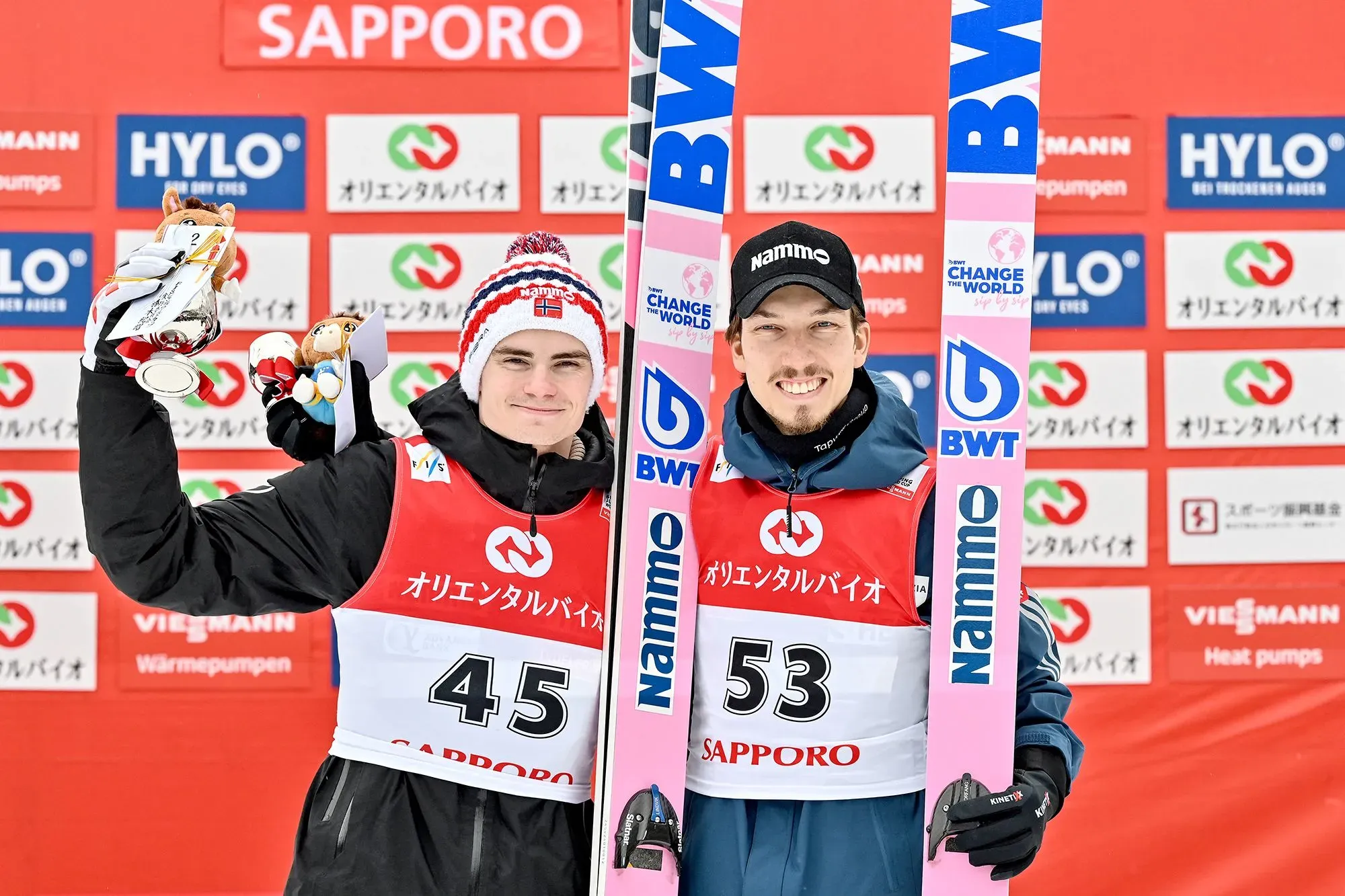 لاعبا القفز على الجليد النرويجيان ماريوس ليندفيك ويوهان أندريه فورفانغ يحتفلان بالميداليات في سابورو، وسط مزاعم التلاعب بالمعدات.